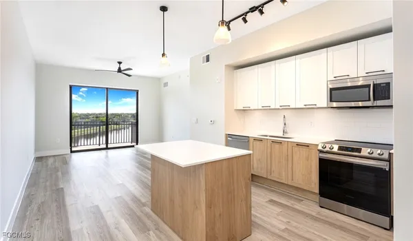 a kitchen with stainless steel appliances a stove a sink and a microwave