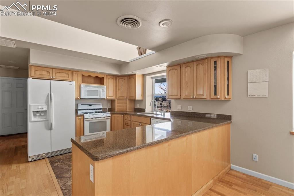 6670 Zercher Road Beulah, CO 81023 - Photo 19 of 37 a kitchen with stainless steel appliances granite countertop a refrigerator a stove and a sink with wooden floor