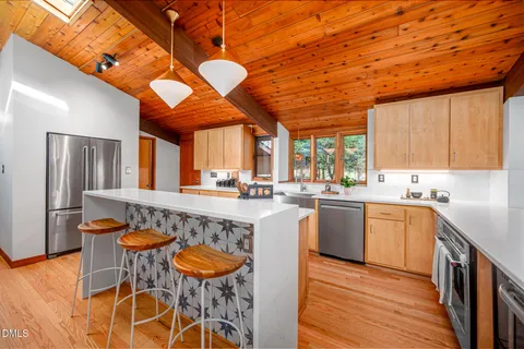 a kitchen with stainless steel appliances granite countertop a sink and wooden floors