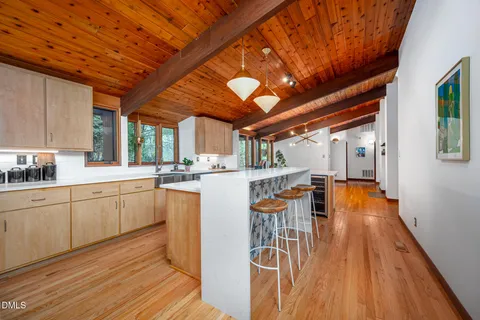 a kitchen with stainless steel appliances granite countertop a table chairs and wooden floors