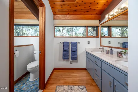 a bathroom with a granite countertop sink and a large mirror