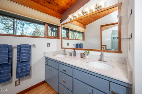 a bathroom with a granite countertop sink and a large mirror