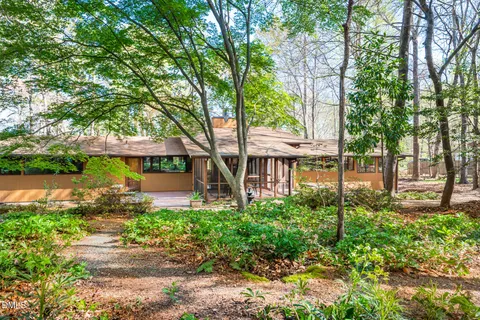 a front view of a house with a garden