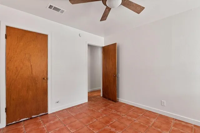 an empty room with a window and a fan