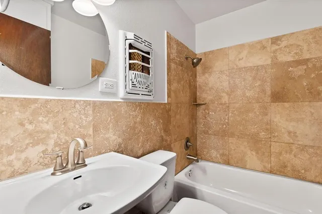 a bathroom with a toilet sink and mirror