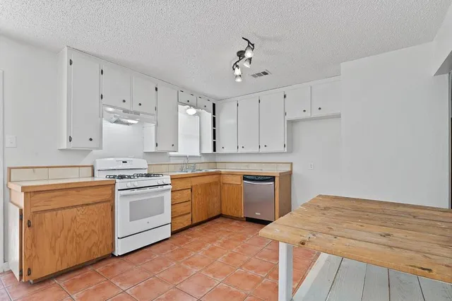 a kitchen with a stove top oven sink and cabinets