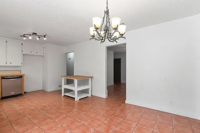a view of a livingroom with a chandelier windows and a chandelier