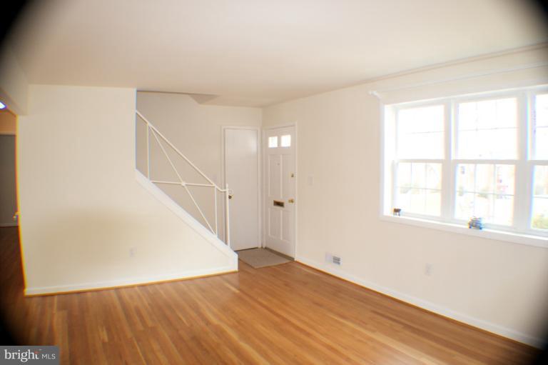 3710 Kayson Street Silver Spring, MD 20906 - Photo 3 of 24 a view of an empty room with wooden floor and a window