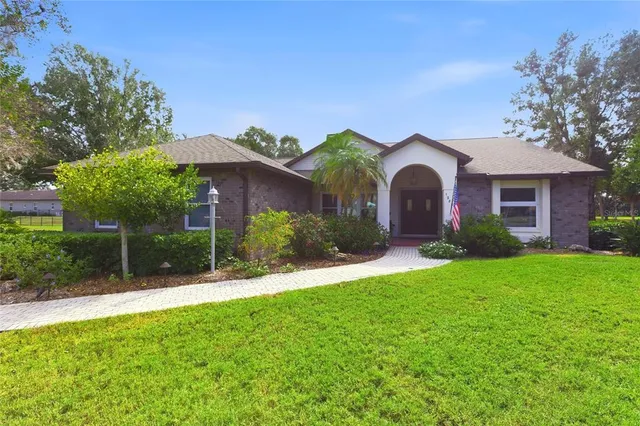 a view of a house with a yard and potted plants