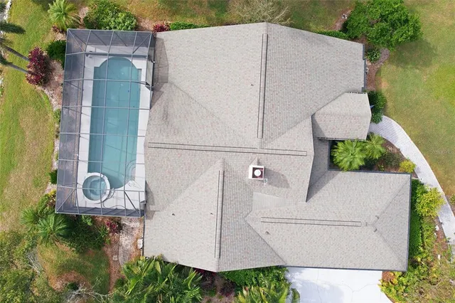 an aerial view of residential houses with outdoor space and trees