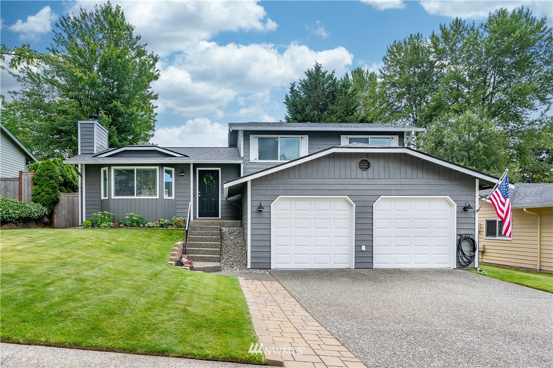 1128 235th Place Southwest Bothell, WA 98021 - Photo 1 of 22 a front view of a house with a garden