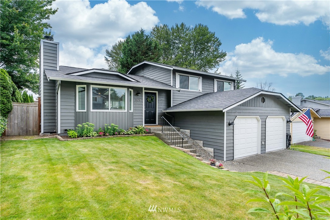 1128 235th Place Southwest Bothell, WA 98021 - Photo 2 of 22 a front view of a house with a yard and garage