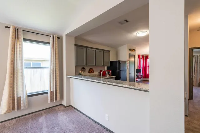 a view of a kitchen with fridge and window