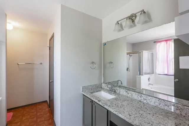 a bathroom with a granite countertop sink and a mirror