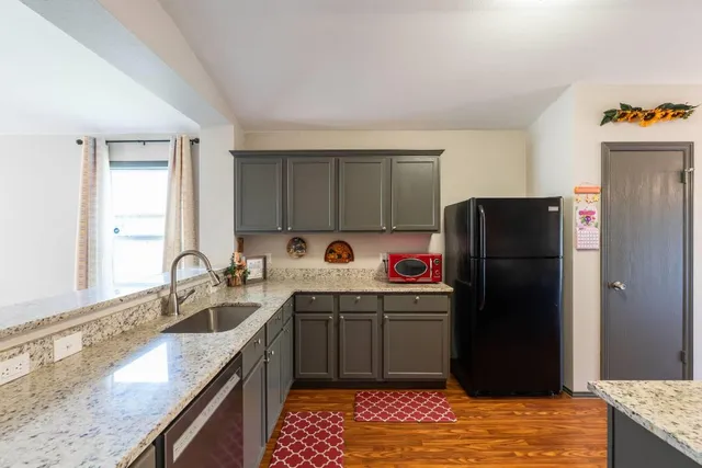 a kitchen with a sink refrigerator and cabinets