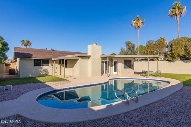 a view of a house with pool and chairs