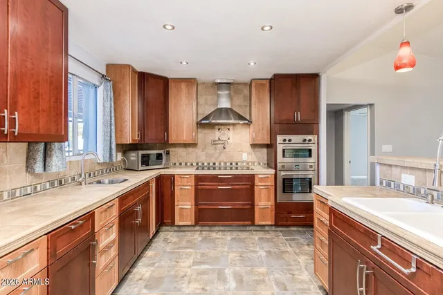 a kitchen with stainless steel appliances granite countertop a stove sink and cabinets
