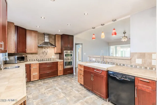 a kitchen with stainless steel appliances granite countertop a sink stove and refrigerator