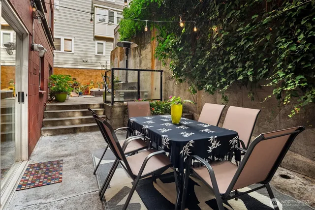 a view of a patio with table and chairs with wooden floor and fence