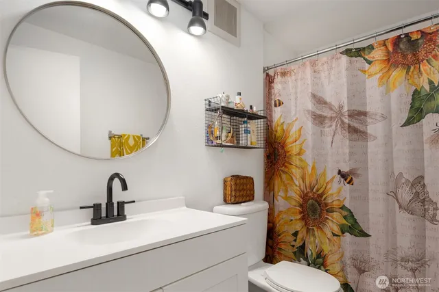 a bathroom with a sink a toilet and a mirror