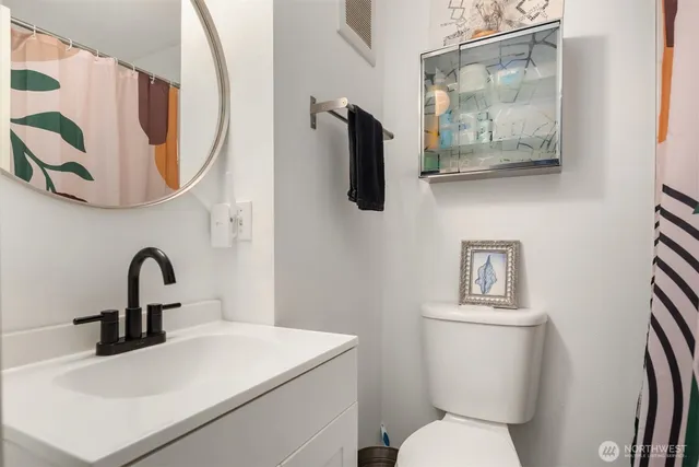 a bathroom with a toilet sink and mirror