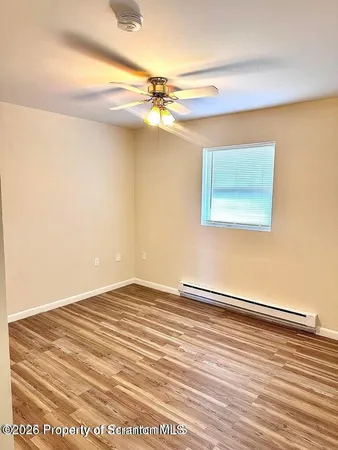 a view of a room with wooden floor and a ceiling fan