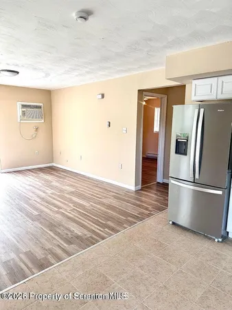 a view of kitchen with refrigerator and wooden floor
