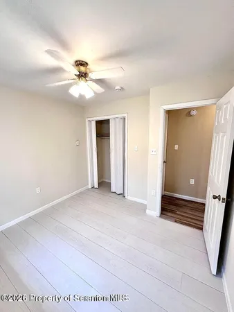 a view of a big room with carpet and a chandelier fan
