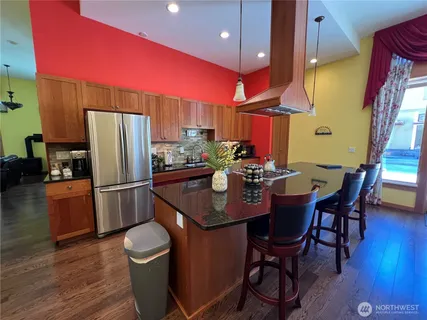 a kitchen with stainless steel appliances a dining table chairs and a refrigerator