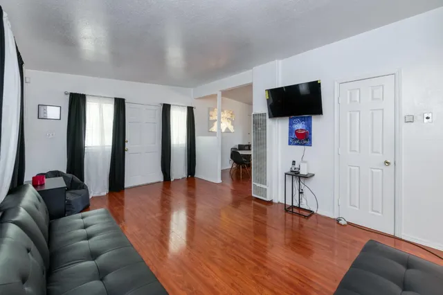 a living room with furniture and a wooden floor