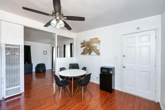 a kitchen with granite countertop a refrigerator a stove a sink dishwasher and a stove with wooden floor