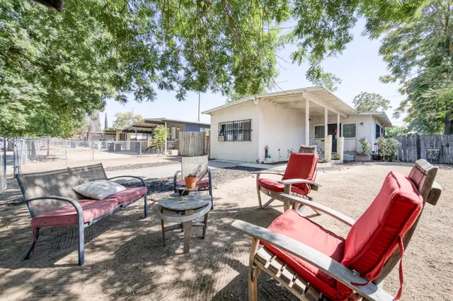 a backyard of a house with barbeque oven table and chairs