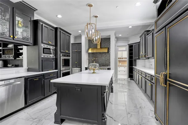 a kitchen with stainless steel appliances kitchen island granite countertop a table chairs in it and wooden floors