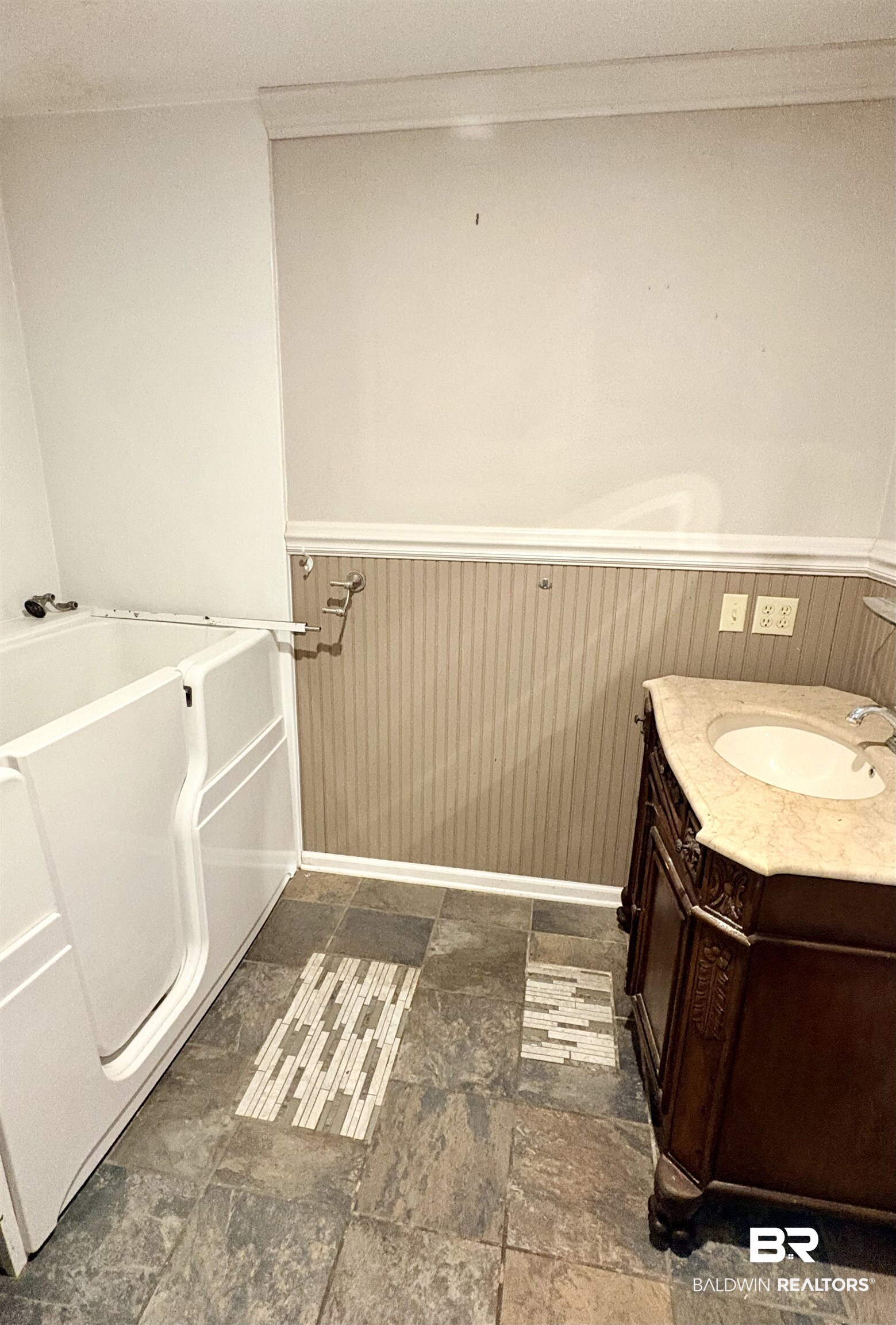 1018 Bates Road Evergreen, AL 36401 - Photo 12 of 21 Bathroom featuring wainscoting, vanity, wooden walls, dark stone finish flooring, and a garden tub