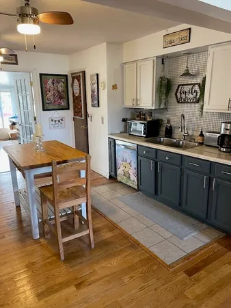 a living room with a table chairs and kitchen view