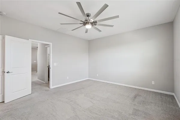 an empty room with a window and a fan