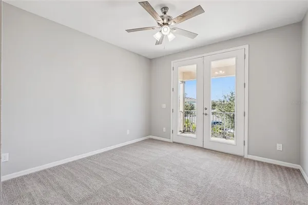 an empty room with a window and a fan