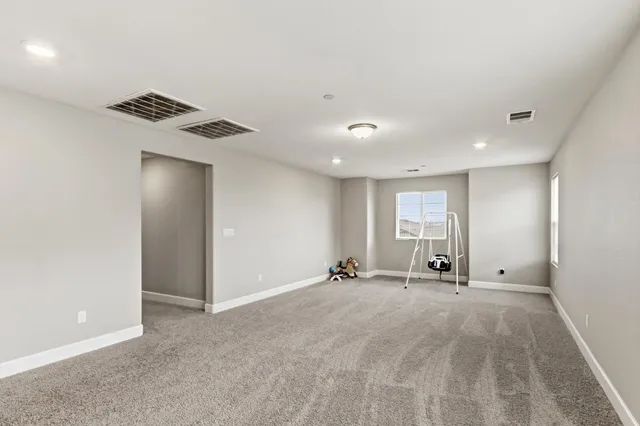 a view of an empty room with windows and a ceiling fan