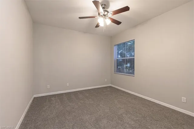 an empty room with chandelier fan