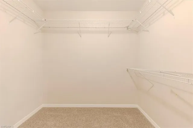 an empty room with a ceiling fan and a rug