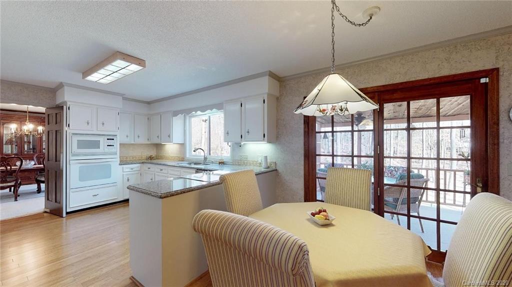 3002 High Ridge Road Charlotte, NC 28270 - Photo 10 of 41 a kitchen with stainless steel appliances granite countertop a stove a sink dishwasher and a dining table with wooden floor