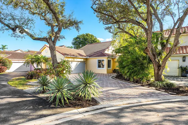 a front view of a house with a tree