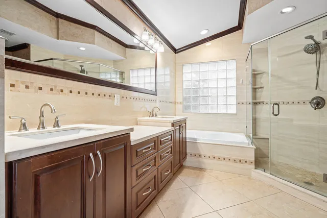 a spacious bathroom with a granite countertop sink a bathtub and next to a window