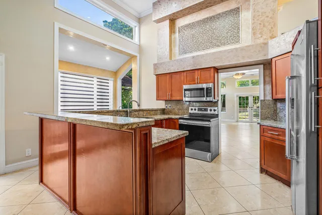 a kitchen with stainless steel appliances granite countertop a refrigerator and a stove