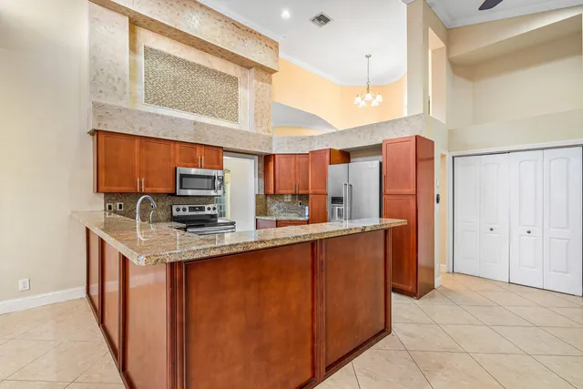 a kitchen with stainless steel appliances granite countertop a stove a sink and a refrigerator