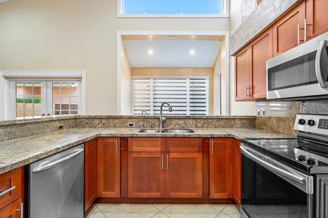a kitchen with stainless steel appliances granite countertop a sink stove and microwave