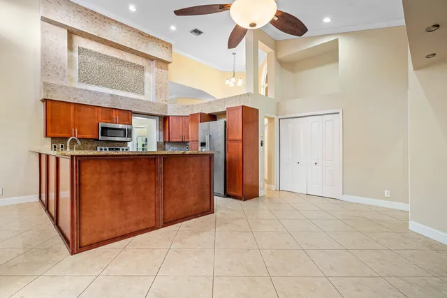 a view of a kitchen with stainless steel appliances granite countertop a refrigerator and a stove top oven