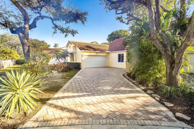 a front view of a house with a yard and trees