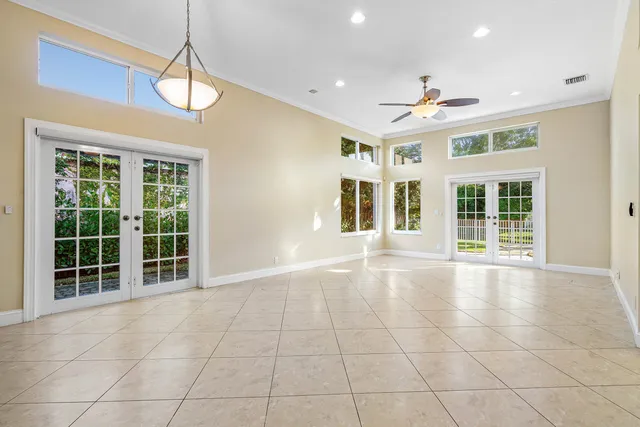 a view of an empty room with a window and chandelier