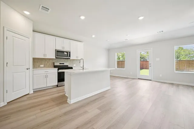 a kitchen with wooden floors and white appliances